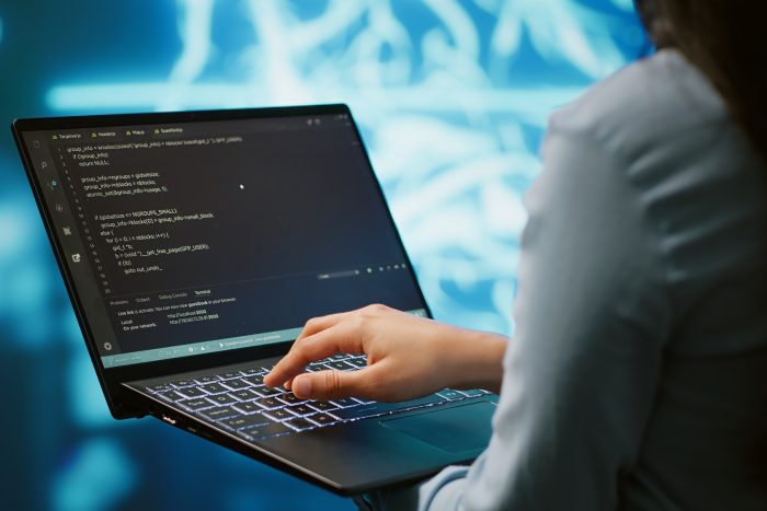 Close up shot of IT expert using AI system and laptop